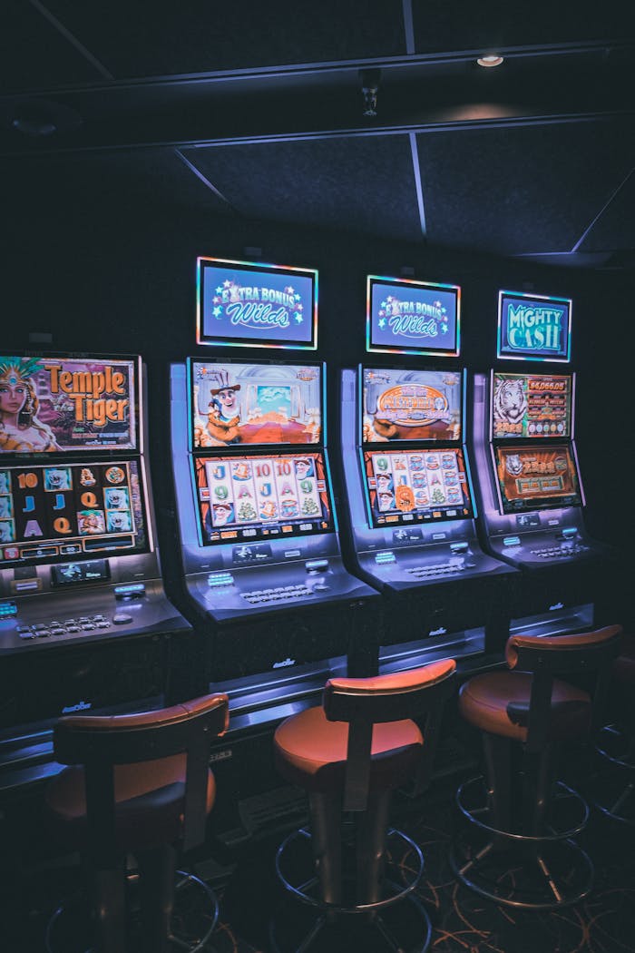 services-05 Row of illuminated slot machines in a dimly lit, empty casino area.